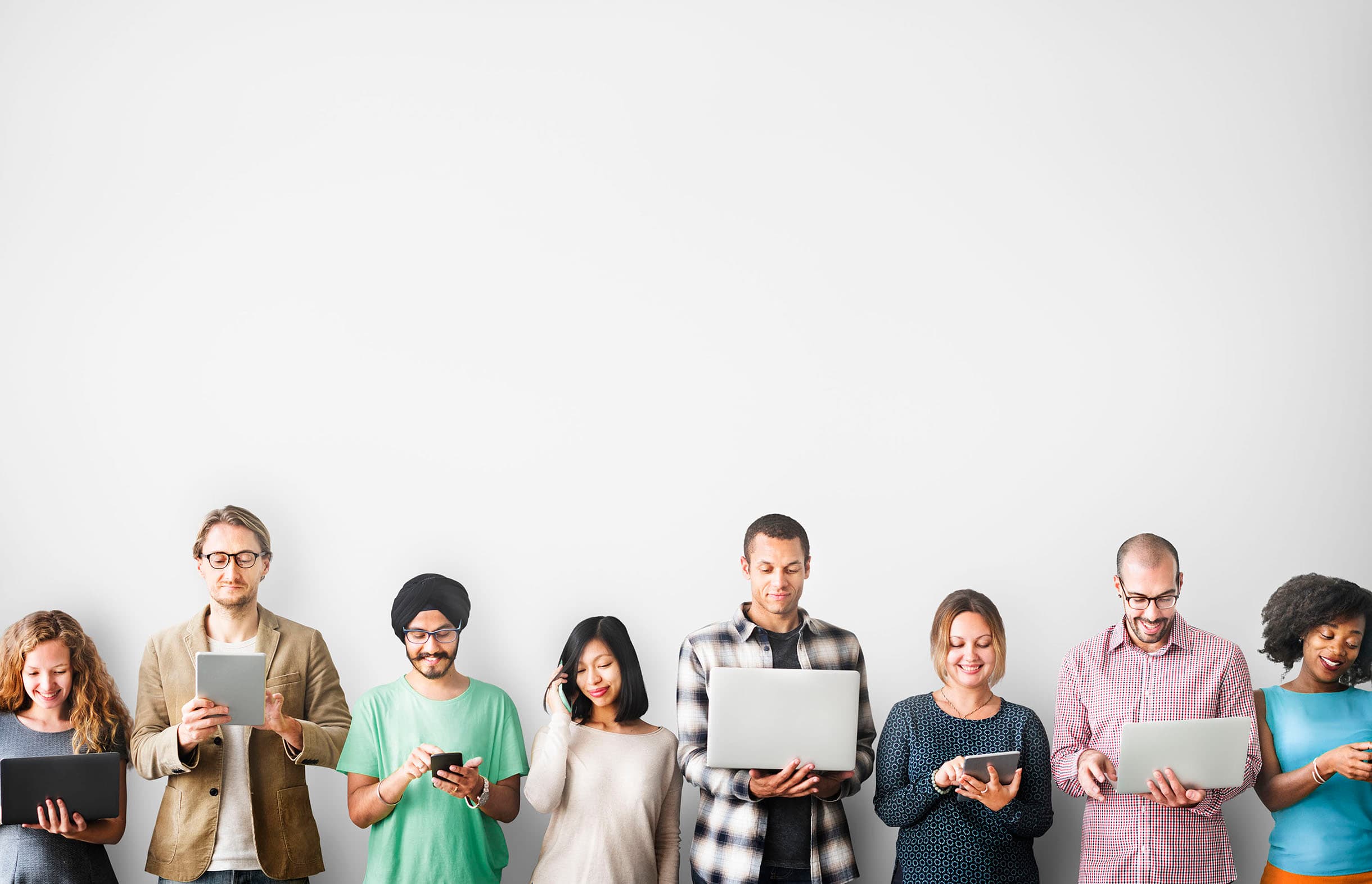 A cross-functional team using laptops, tablets, and phones.